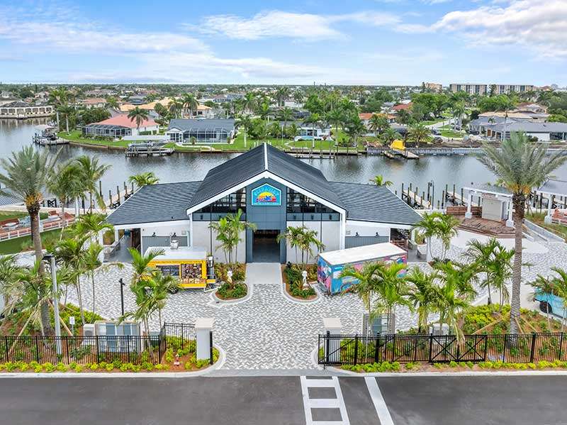 A waterfront venue with palm trees and pathways.